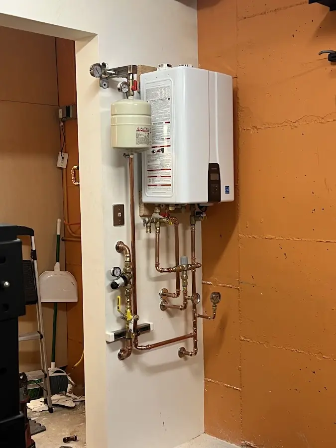 Plumbing technician inspecting water heater connections in North Salem